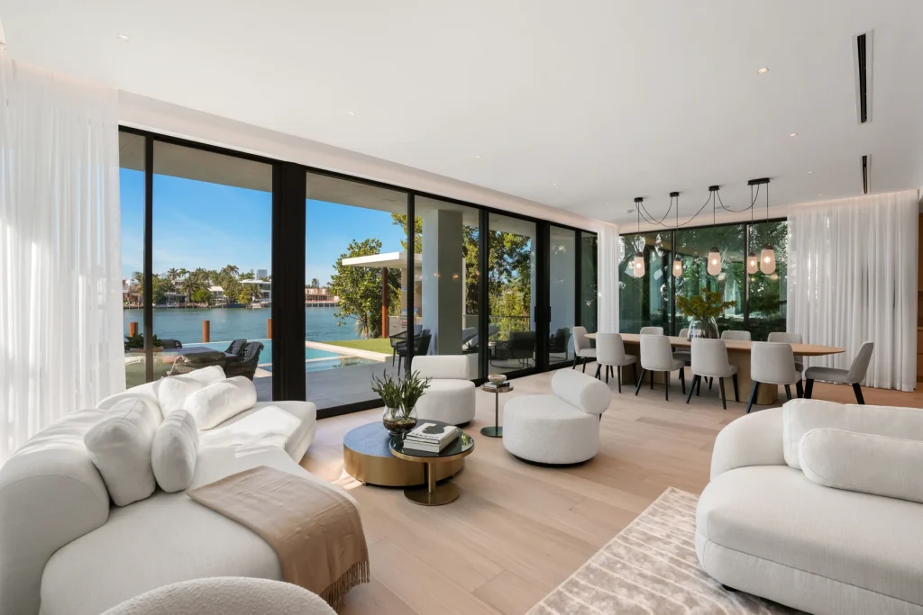 Luxurious living room with panoramic windows offering waterfront views in a Miami waterfront property for sale.