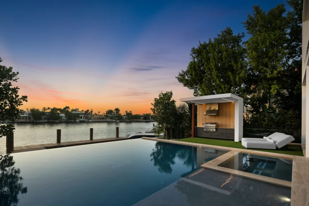 Infinity-edge pool at sunset overlooking the Miami waterfront property for sale.