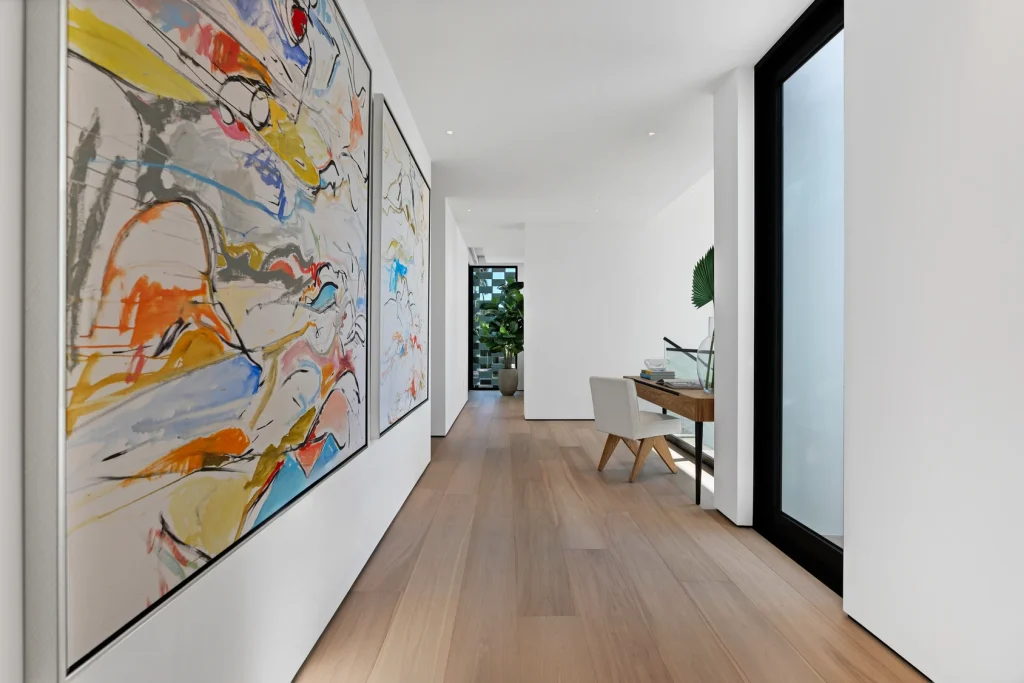 Art-filled hallway leading to bright spaces 